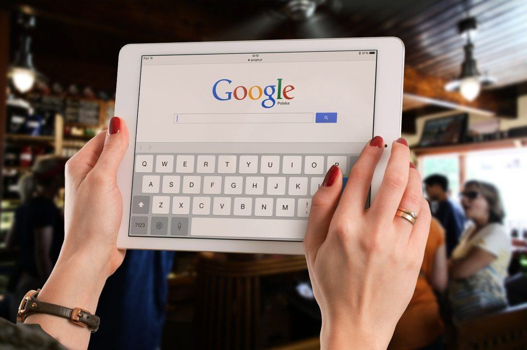 female hands on an ipad with Google search loaded