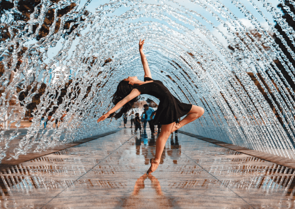 woman dancing under a fountain of water